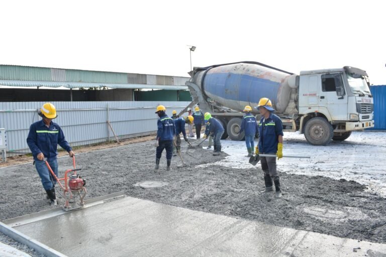 Workers pouring concrete slab